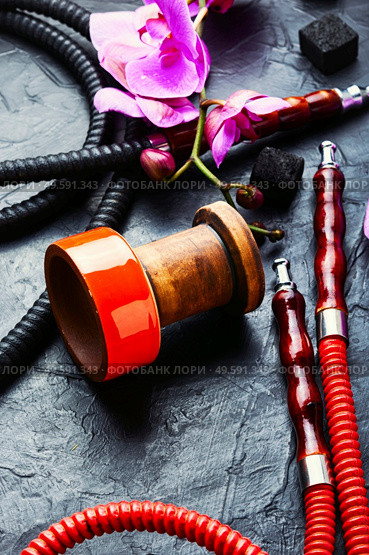 Hookah mouthpiece and hookah cup on pink orchid background.Kalian on flower tobacco. Hookah with floral aroma. Стоковое фото, агентство Ingram Publishing / Фотобанк Лори