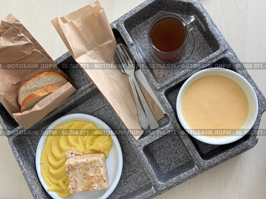 Hospital food on a hospital tray. Different dishes are arranged in the tray compartments. Стоковое фото, фотограф Vadzim Yakubovich / Фотобанк Лори
