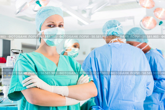 Hospital - surgery team in the operating room or Op of a clinic operating on a patient in emergency. Surgeons operating patient in operation theater. Стоковое фото, агентство Ingram Publishing / Фотобанк Лори