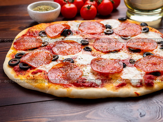 hot homemade Italian pepperoni pizza with salami, mozzarella and olives. Стоковое фото, фотограф Natalia Gdovskaia / Фотобанк Лори