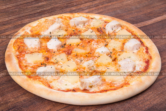 Hot pizza slice with melting cheese on a rustic wooden table. Стоковое фото, фотограф Aleksandr Ryzhov / Фотобанк Лори