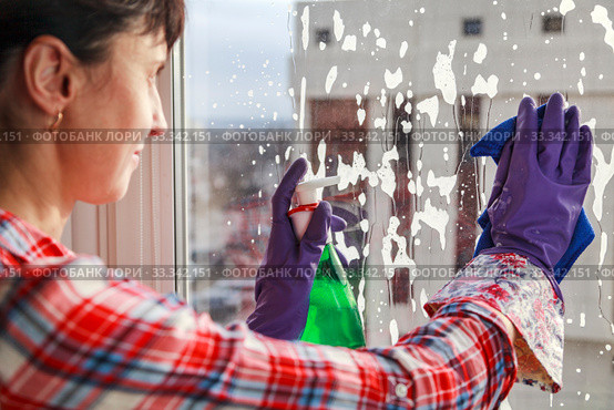 Housework concept, Spring cleanup, young girl in gloves cleaning window with blue rag and spray detergent. Стоковое фото, фотограф Evgenii Mitroshin / Фотобанк Лори