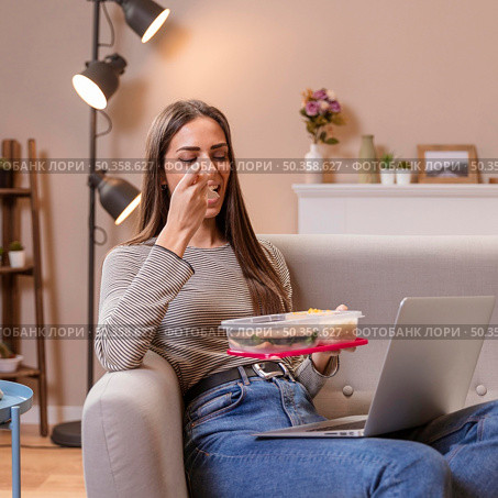 hungry businesswoman eating sitting sofa. Стоковое фото, агентство Ingram Publishing / Фотобанк Лори