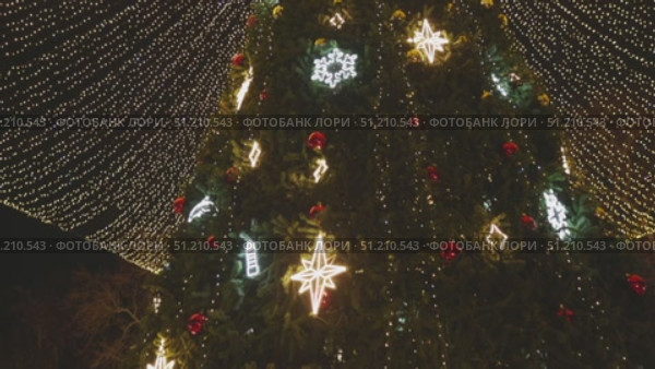 Illuminated Christmas tree in the night city. Christmas tree with lights and decoration. Стоковое видео, видеограф Wonderful nature / Фотобанк Лори