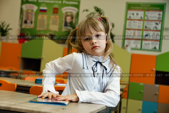 Imaginative First-Grader Pondering in a Vibrant Classroom Setting Filled With Colors and Creativity. Стоковое фото, фотограф Aleksandr Golubev / Фотобанк Лори