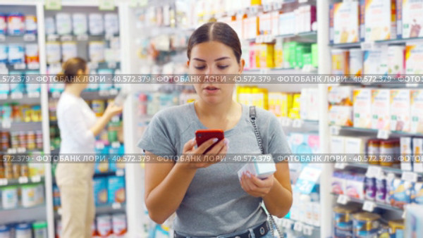 In pharmacy visitor scan QR Code and reads composition of cream for problematic skin. Стоковое видео, видеограф Яков Филимонов / Фотобанк Лори