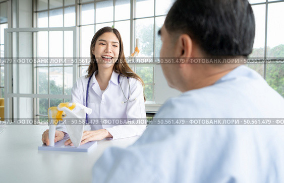 In the hospital office, A medical explains about the care and treatment of osteoarthritis to a patient. Стоковое фото, агентство Ingram Publishing / Фотобанк Лори