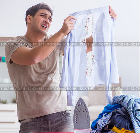 Inattentive husband burning clothing while ironing. Стоковое фото, фотограф Elnur / Фотобанк Лори