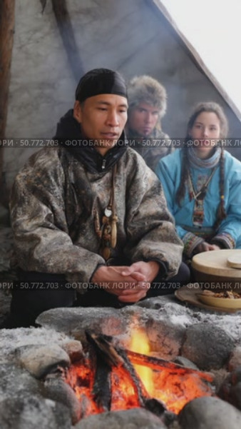 Indigenous man telling stories around campfire in tent. Стоковое AI-видео, аниматор Юрий Поздников / Фотобанк Лори