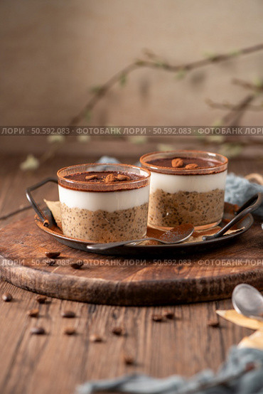 Indulge in a luscious tiramisu-inspired chia pudding, layered with creamy coffee-infused chia and a rich chocolate topping. A delightful breakfast or dessert option that combines classic tiramisu flavors with wholesome ingredients for a convenient and satisfying treat. Стоковое фото, агентство Ingram Publishing / Фотобанк Лори