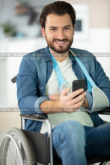 injured man in wheelchair making telephone call. Стоковое фото, агентство Ingram Publishing / Фотобанк Лори