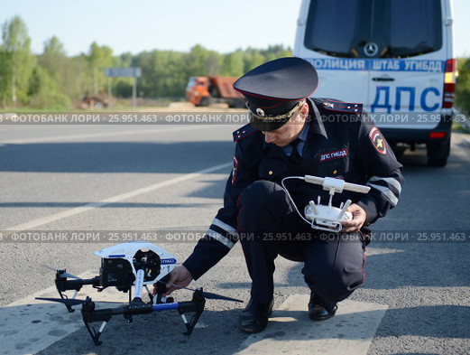 Инспектор дорожно-патрульной службы полиции контролирует трассу с помощью квадрокоптера (2016 год). Редакционное фото, фотограф Free Wind / Фотобанк Лори