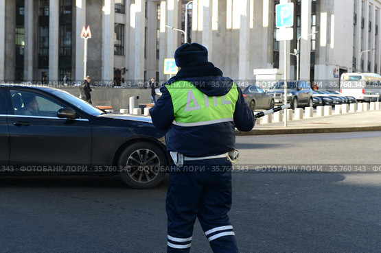 Инспектор дорожно-патрульной службы полиции останавливает автомобиль в центре Москвы (2017 год). Редакционное фото, фотограф Free Wind / Фотобанк Лори