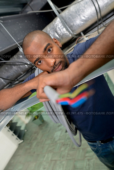 installing an electric wire at work. Стоковое фото, агентство Ingram Publishing / Фотобанк Лори