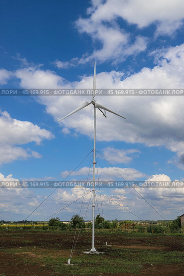 Использование ветрогенератора на ферме в России. Windmill as a source of renewable energy and sustainable resource. Wind turbine. Green energy. Стоковое фото, фотограф Ekaterina M / Фотобанк Лори