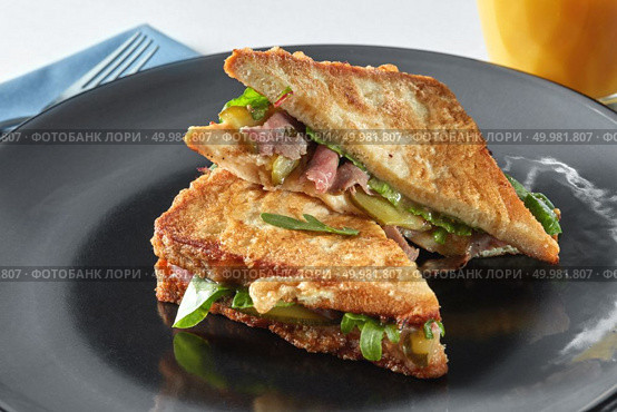 Italian ciabatta sandwich with parma ham and herbs on black plate. Italian ciabatta sandwich with parma ham and herbs. Стоковое фото, агентство Ingram Publishing / Фотобанк Лори