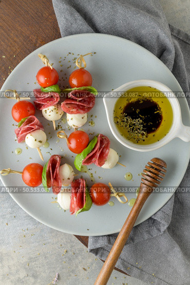 Italian style appetizer, antipasto skewer or caprese on a stick with basil, salami, mozarella and tomatoes. Стоковое фото, агентство Ingram Publishing / Фотобанк Лори