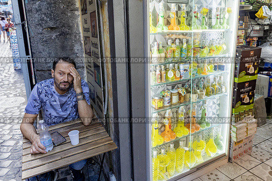 Италия. Неаполь. Мужчина в кафе у витрины с лимончелло. Italy. Naples. A man in a cafe at the window with limoncello. Редакционное фото, фотограф Алексей Смышляев / Фотобанк Лори