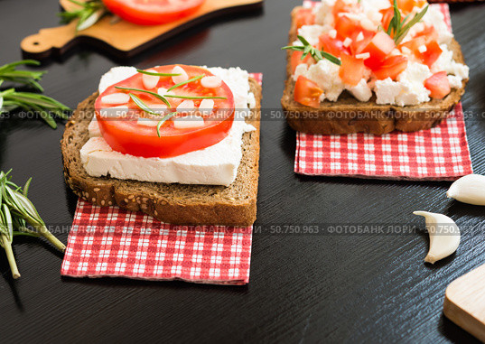 Итальянская брускетта с белым козьим сыром, помидорами, чесноком и розмарином. Бутерброд с сыром и овощами. Здоровое питание. Вегетарианское питание. Healthy food. Vegetarian food. Italian bruschetta with White Goat Cheese with Tomatoes, Garlic and Rosemary. Cheese Vegetable Sandwich. Стоковое фото, фотограф AllNikArt / Фотобанк Лори