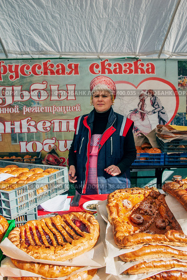 Измайловский парк, Москва, Россия - 1 октября 2016 года: потомки казаков на ярмарке и казачьем сборе. Казаки в национальной одежде продают национальную домашнюю выпечку ручной работы-пироги. Редакционное фото, фотограф Оксана Медведева / Фотобанк Лори