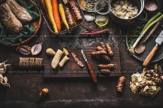 Jerusalem artichoke peeling preparation on rustic kitchen table with pot, diced vegetables, oil and ingredients, top view. Healthy and clean seasonal food cooking and eating concept. Стоковое фото, агентство Ingram Publishing / Фотобанк Лори