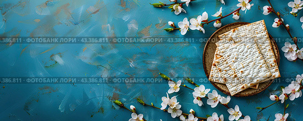 Jewish matzo in a plate on a blue background surrounded by white spring flowers. The feast of the Jewish Passover. Стоковое AI-изображение, AI-художник Ярославский Максим / Фотобанк Лори