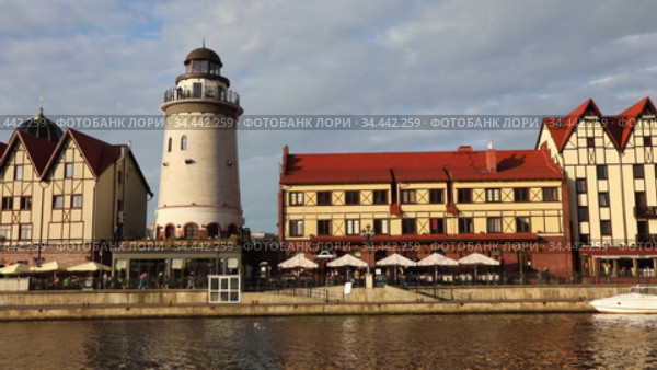 KALININGRAD, RUSSIA - JULY 29, 2020: Fish village district with a lighthouse on the bank of the Staraya Pregolya river in the rays of the setting sun. Kaliningrad, Russia. Редакционное видео, видеограф Алексей Кузнецов / Фотобанк Лори