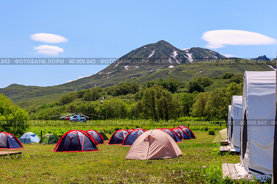 Kamchatka, Russia - July 8, 2018: Helicopter is landing near the tent camping near Kuril Lake. Редакционное фото, фотограф VittoriaChe / Фотобанк Лори