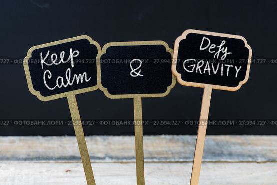 Keep Calm and Defy Gravity message written with chalk on mini blackboard labels. Стоковое фото, фотограф Constantin Stanciu / Smarterpix / Фотобанк Лори