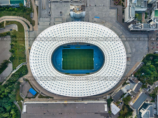 KIEV, UKRAINE - July 19, 2018. Panoramic view strrictly above the National Sports Complex Olimpiysky with surrounding area of Stadium in a summer time at sunset. Aerial view from drone. Top view.. KYIV, UKRAINE - July 19, 2018. Aerial viev from drone to the stadium -National Sports Complex NSC Olimpiysky with the area around the stadium. Редакционное фото, агентство Ingram Publishing / Фотобанк Лори