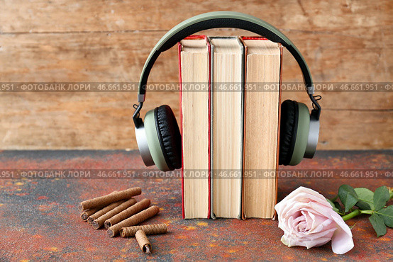 Книги, современные наушники, сладости и цветы на столе. Концепция аудиокниги. Стоковое фото, фотограф Pixel_shot / Фотобанк Лори