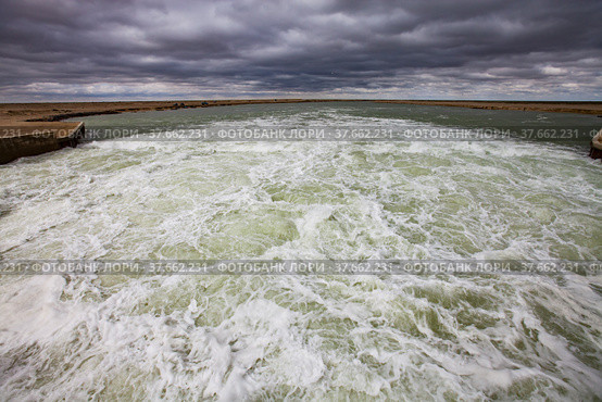 Kok-aral, Kazakhstan - May 03, 2012: Aral Sea Kok-aral dam. Turbulent water after dam. Stormy clouds on horizon. Стоковое фото, фотограф Alexey Rezvykh / Фотобанк Лори