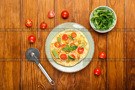 Композиция с вкусной мини-пиццей и резаком на деревянном фоне. Стоковое фото, фотограф Pixel_shot / Фотобанк Лори