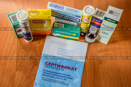 Концепция необходимости вакцинации против коронавирусной инфекции COVID-19,  лечения нового штамма «Омикрон» и других ОРВИ. Сертификат, противовирусные препараты, витамины (2022 год). Редакционное фото, фотограф Владимир Устенко / Фотобанк Лори