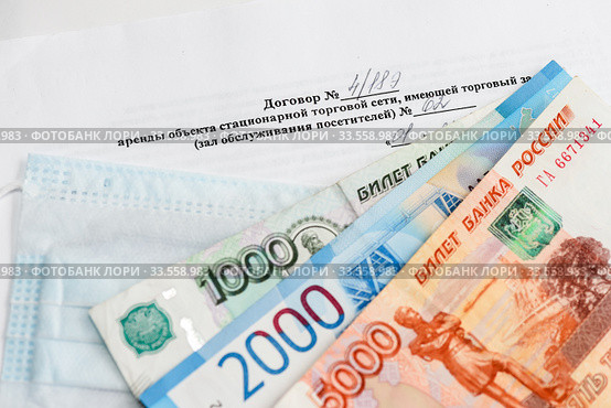 Коронавирус. Договор аренды помещения в торговом зале магазина, стопка российских денег и маска. Стоковое фото, фотограф Игорь Низов / Фотобанк Лори
