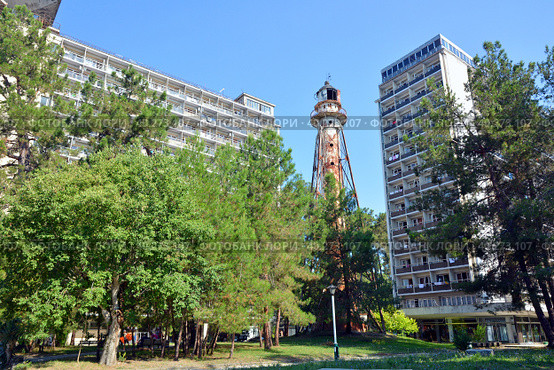 Корпуса Объединения пансионатов "Курорт Пицунда" - "Маяк" и "Амзара". Между ними - достопримечательность "Старинный маяк" (Республика Абхазия, Гагрский район, Пицунда) (2021 год). Редакционное фото, фотограф Александр Замараев / Фотобанк Лори