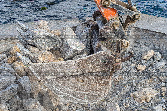 Ковш экскаватора загружает крупные камни. Excavator bucket filled with stones and pieces of concrete. Стоковое фото, фотограф Татьяна Д / Фотобанк Лори