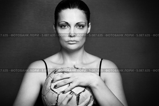 Красивая женщина спортивного типа сжимает в руках старый футбольный мяч. Стоковое фото, фотограф Николай Винокуров / Фотобанк Лори