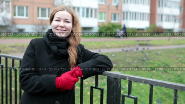 Красивая женщина стоит на мостике, облокотившись о перила и смотрит в камеру. Стоковое видео, видеограф Кекяляйнен Андрей / Фотобанк Лори