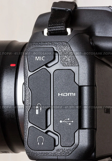 Krasnodar, Russia - December 28, 2023: side view of the Canon eos  R7 mirrorless camera with rubber connector covers for connecting various devices. Редакционное фото, фотограф Андрей С / Фотобанк Лори
