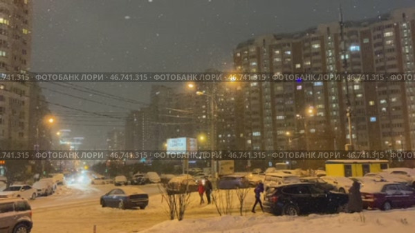 Красногорск. Люди гуляют по улице. Снегопад вечером в Подмосковье (2022 год). Редакционное видео, видеограф Анастасия / Фотобанк Лори