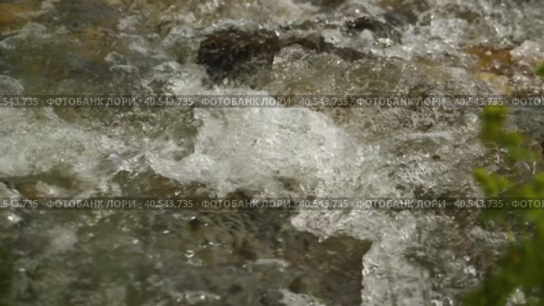 Крупный план потока чистой талой воды, пенящейся при ударе о камни. Замедленная съемка горного ручья. Живая природа. Фоновое видео. Вид сбоку с вершины. Стоковое видео, видеограф Воловодов Владимир / Фотобанк Лори