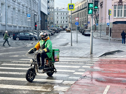 Курьер Сбермаркета на мотобайке едет по улице Неглинная в Москве. Редакционное фото, фотограф Овчинникова Ирина / Фотобанк Лори