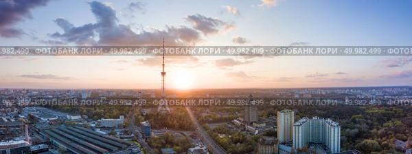 Kyiv evening panoramic view. Modern illuminated TV tower in the middle of composition. Drone photography from aerial view. Panoramic view of the city with a TV tower in Kiev, Ukraine on a beautiful sunset. Стоковое фото, агентство Ingram Publishing / Фотобанк Лори