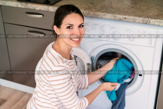 lady putting clothes washing machine. Стоковое фото, агентство Ingram Publishing / Фотобанк Лори