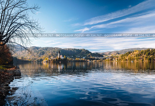 Lake Bled in the Alpine mountains in autumn under blue sky. Стоковое фото, агентство Ingram Publishing / Фотобанк Лори