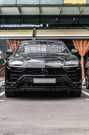 Lamborghini Urus parked on the street in Moscow. Black premium SUV supercar in front of office building. Редакционное фото, фотограф Константин Григорьев / Фотобанк Лори