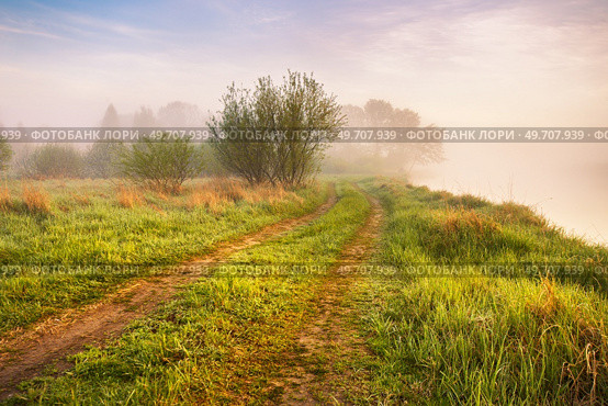 Landscape with sunrise over river. Morning beautiful clouds on sky. Water reflection scene. Rural dirt road on riverbank. Calm foggy weather. Green filed and meadow. Europe, Belarus. Стоковое фото, агентство Ingram Publishing / Фотобанк Лори
