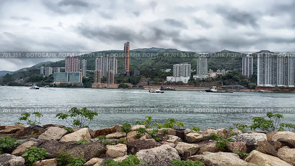 Lantau Island, Hong Kong - April 09, 2024: Lantau Island offers a picturesque view of Hong Kong's skyline and surrounding waters under a cloudy sky. Стоковое фото, фотограф Кривошеина Елена Леонидовна / Фотобанк Лори