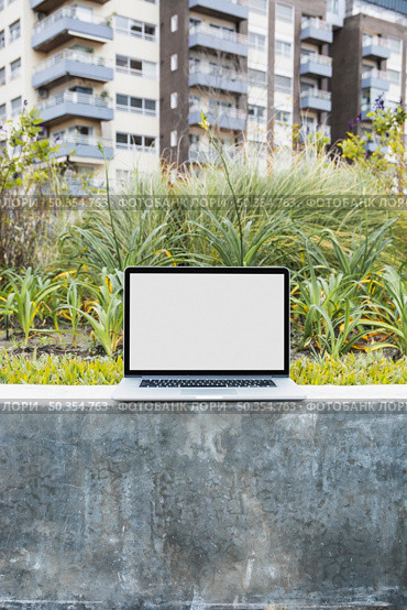 laptop retaining wall front apartment. Стоковое фото, агентство Ingram Publishing / Фотобанк Лори